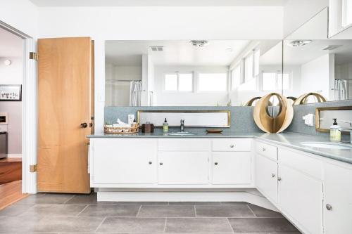 a kitchen with white cabinets and a sink at LA Huge Mid Century Guesthouse Patio LAX Beach in Los Angeles