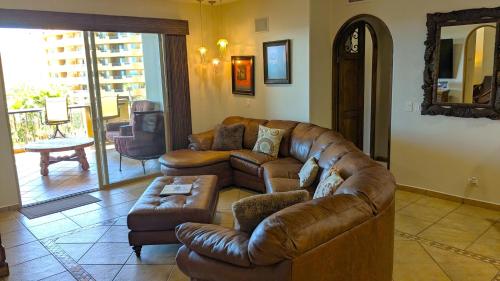 a living room with a leather couch and a table at Bella Sirena 304-A - Elegant Oceanview Condo on Sandy Beach in Puerto Peñasco