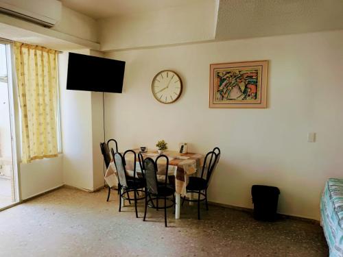 阿卡普爾科的住宿－Las Torres Gemelas，一间设有桌子和墙上时钟的餐厅