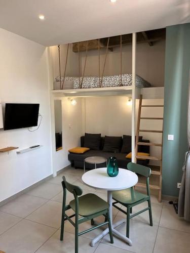 a living room with a table and chairs and a couch at Le Pressensé in Vénissieux