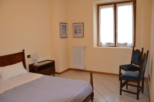 1 dormitorio con 1 cama, 1 silla y 1 ventana en 10 minuti dall'areoporto Orio al Serio BGY, en Zanica