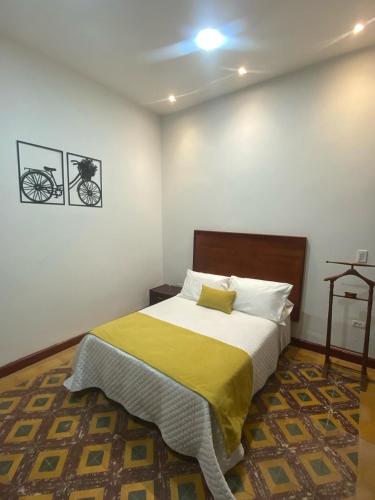 a bedroom with a bed with a yellow blanket at Hotel Boutique Iyarí in Palmira