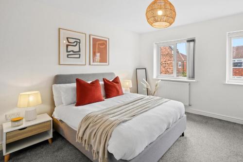una camera da letto con un grande letto con cuscini rossi di Greaves House by Truestays - 3 Bedroom House in Failsworth, Manchester a Manchester