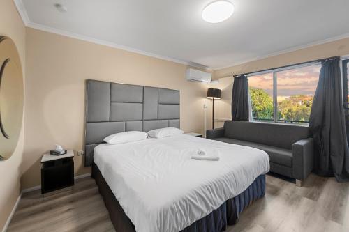 a bedroom with a large bed and a couch at S1 Motel in Brisbane
