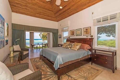 a bedroom with a bed and a view of the ocean at Peaceful Ocean Front Beach House in Bodden Town in Bodden Town