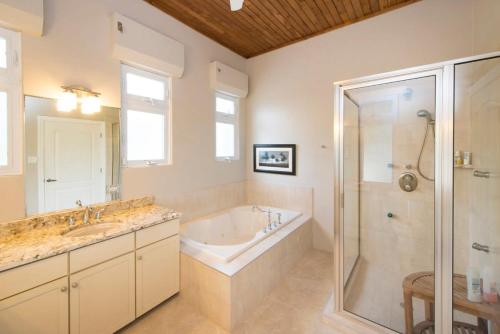 duża łazienka z wanną i prysznicem w obiekcie Peaceful Ocean Front Beach House in Bodden Town w mieście Bodden Town