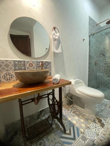 a bathroom with a sink and a toilet and a mirror at Hotel Boutique Iyarí in Palmira