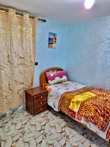 - une chambre avec un lit et une commode dans l'établissement Résidence SEHRAWILOCATION, à Errachidia