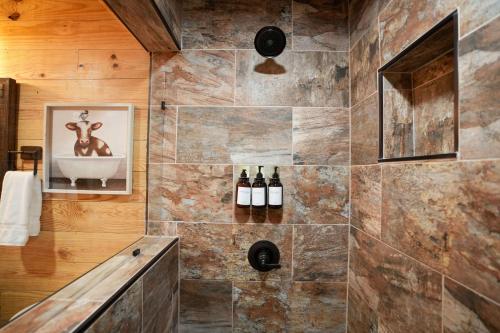 een badkamer met een douche en flessen wijn bij New Lux Cabin Hot Tub FirePit Games 