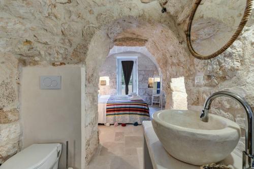 La salle de bains en pierre est pourvue d'un lavabo et de toilettes. dans l'établissement 3 bedrooms villa with private pool enclosed garden and wifi at San Vito dei Normanni, à San Vito dei Normanni