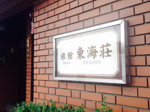 a sign on the side of a brick wall at Asakusa Ryokan Toukaisou in Tokyo