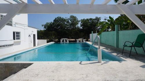 - une piscine avec une chaise à côté d'un bâtiment dans l'établissement See Belize Sea View Vacation Rentals, à Belize City