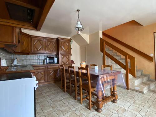 uma cozinha com uma mesa de madeira e cadeiras em Gite le Saint André em Villers-sur-Port