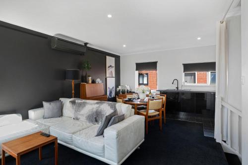 a living room with a white couch and a table at Halifax Muse Pet Friendly Townhouse in Adelaide