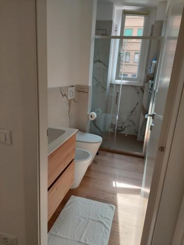 a bathroom with a toilet and a glass shower at Casa Mappamondo in Lecco