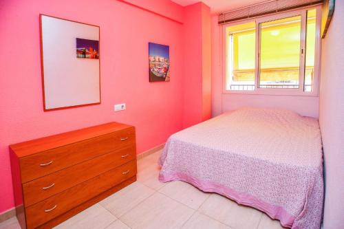 um quarto com uma cama, uma cómoda e uma janela em Equipped Centric Apartment with large terrace em Lloret de Mar