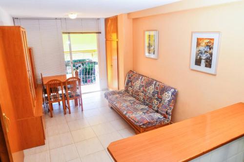 uma sala de estar com um sofá e uma mesa em Equipped Centric Apartment with large terrace em Lloret de Mar