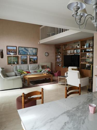 un salon avec un canapé et une table dans l'établissement Bed and breakfast jeux olympiques 2024, à Vauréal