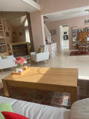 un salon avec une table basse et un canapé dans l'établissement Bed and breakfast jeux olympiques 2024, à Vauréal