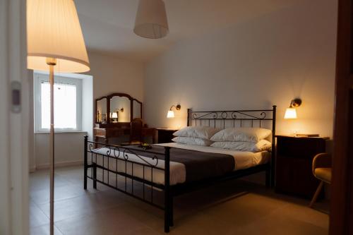 a bedroom with a bed with a lamp and a mirror at Residenza Il Panorama della Ciociaria in Castro dei Volsci