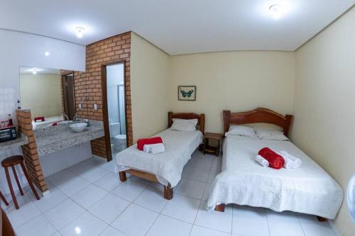 - une chambre avec 2 lits et une salle de bains avec lavabo dans l'établissement Casa 3/4 aconchegante no Vale do Capão, à Palmeiras