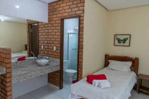 La salle de bains est pourvue d'un lit, d'un lavabo et d'un miroir. dans l'établissement Casa 3/4 aconchegante no Vale do Capão, à Palmeiras