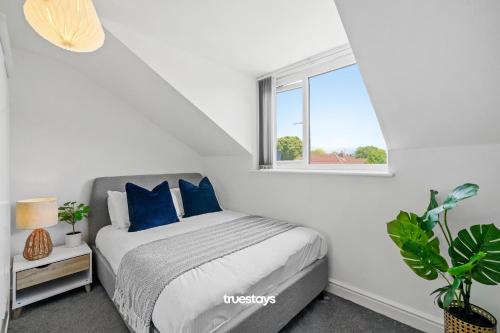 - une chambre avec un lit doté d'oreillers bleus et d'une fenêtre dans l'établissement 6 Sarah House by Truestays - 2 Bedroom Apartment - FREE Wifi & Parking, à Manchester