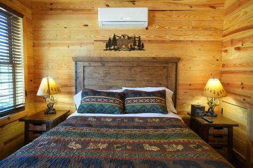a bedroom with a bed in a log cabin at CampQYB- Modern Lux Cabin Hot Tub FirePit Games in Runaway Bay