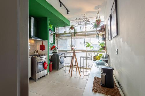uma pequena cozinha com paredes verdes e uma mesa em Apartamento no Centro - 1 quarto Edifício Copan em São Paulo