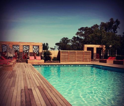 una gran piscina con terraza de madera en Isola Hôtel, en Borgo