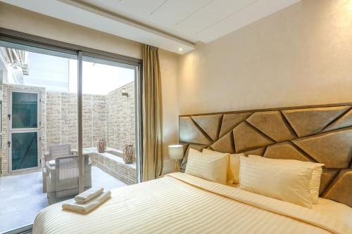 a bedroom with a large bed and a balcony at Résidence Sheren - Maarif in Casablanca