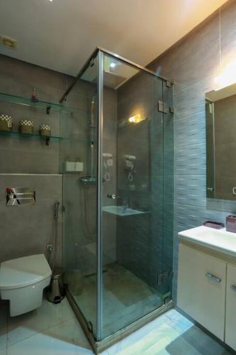 a bathroom with a glass shower with a toilet at Résidence Sheren - Maarif in Casablanca