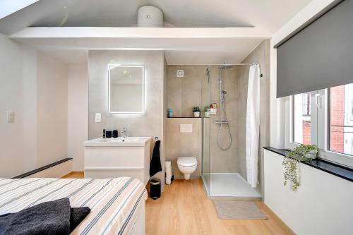 uma casa de banho com um chuveiro, uma cama e um lavatório. em Le cocon de Chênée em Chênée
