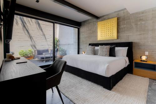 a bedroom with a large bed and a desk and a chair at Capitalia Moliere Masaryk in Mexico City