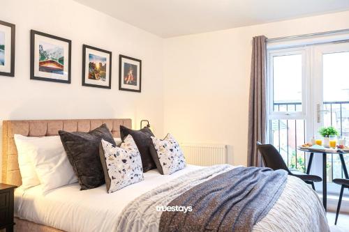 um quarto com uma cama grande e almofadas em Ambassador House by Truestays - Luxury 4 Bedroom House in Stoke-on-Trent em Etruria