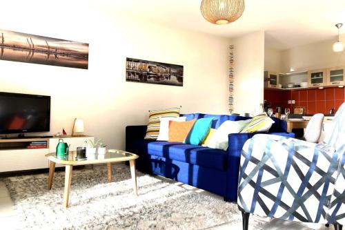 un salon avec un canapé bleu et une table dans l'établissement Le Maraîcher-Appart proche centre avec terrasse, à Nantes