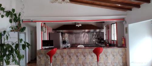 uma cozinha com cadeiras vermelhas no meio de uma sala em Quinta imperio del sol em Latacunga