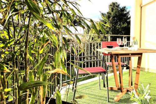 d'une table et de deux chaises sur un balcon avec une table et des verres à vin dans l'établissement Le Maraîcher-Appart proche centre avec terrasse, à Nantes