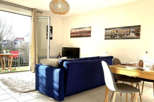un salon avec un canapé bleu et une table dans l'établissement Le Maraîcher-Appart proche centre avec terrasse, à Nantes