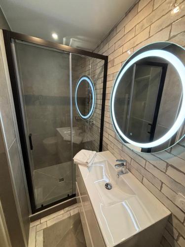 une salle de bain avec un lavabo, une douche et un miroir dans l'établissement le quai, à Sète