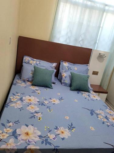ein Bett mit einer blauen Decke mit Blumen drauf in der Unterkunft Swahili home-Mbeya CBD in Mbeya