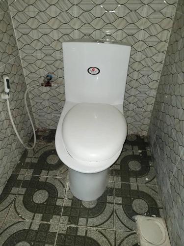 ein Badezimmer mit einem weißen WC in einer Kabine in der Unterkunft Swahili home-Mbeya CBD in Mbeya