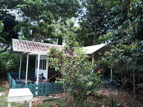 une petite maison avec une clôture verte devant elle dans l'établissement Hostal Suna Vito, à Puerto Asís