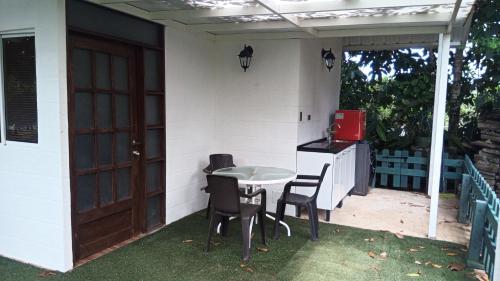 a patio with a table and chairs and a kitchen at Hostal Suna Vito in Puerto Asís