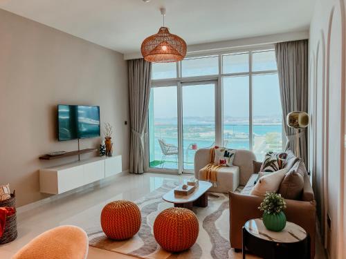 a living room with a couch and a tv at Oceanfront Escape: Stylish 1 BR in Beachfront in Dubai