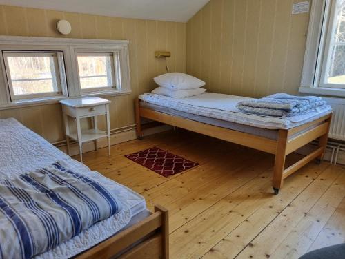 a bedroom with two beds and a wooden floor at Sofielund Vandrarhem & Camping in Sala