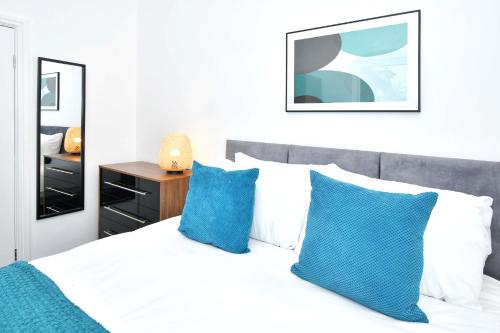 1 dormitorio con cama blanca y almohadas azules en Gilman House by Truestays - 4 Bedroom House in Stoke-on-Trent en Etruria