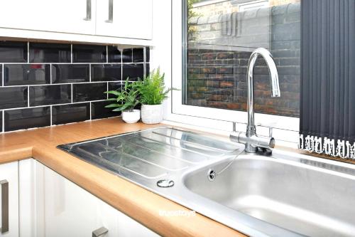 eine Küche mit einem Waschbecken und einem Fenster in der Unterkunft Gilman House by Truestays - 4 Bedroom House in Stoke-on-Trent in Etruria