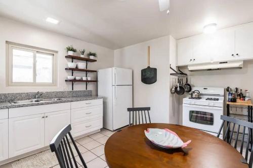 a kitchen with a wooden table and white appliances at Casa Italia -2BR- FREE Driveway parking for 2 cars in San Diego