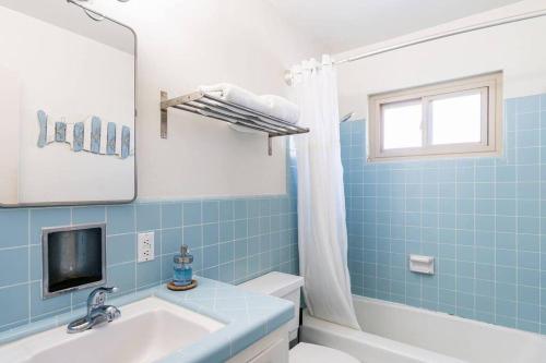 La salle de bains bleue est pourvue d'un lavabo et d'une baignoire. dans l'établissement Casa Italia -2BR- FREE Driveway parking for 2 cars, à San Diego